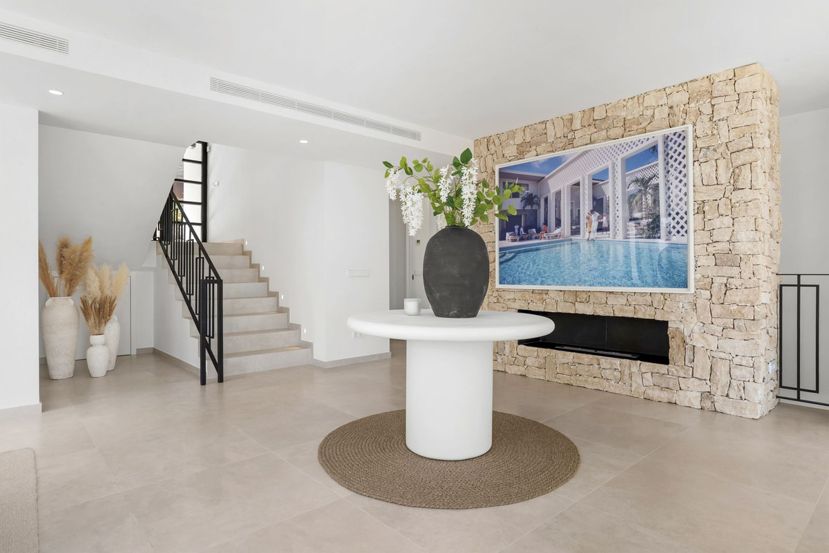 Entrance hall with natural stone wall, gas fire and staircase