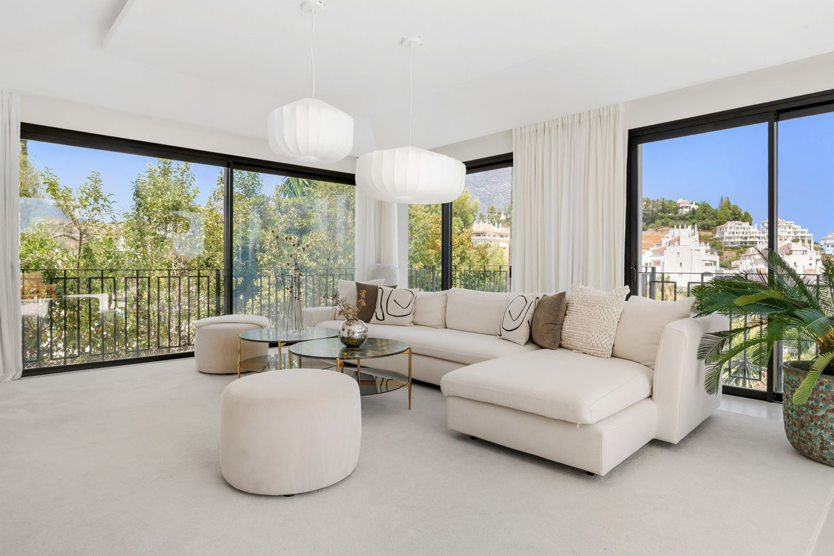 Living room with floor-to-ceiling windows onto garden and mountains