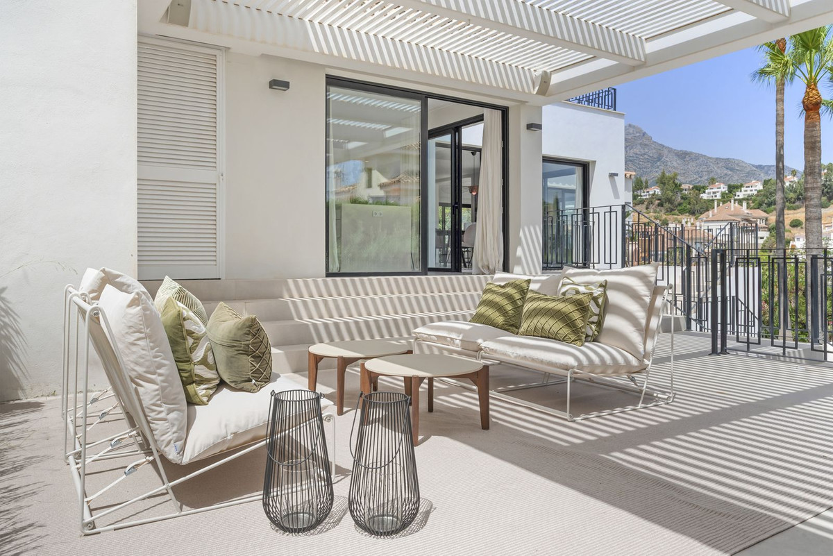 Covered pergola terrace with seating group and mountain view