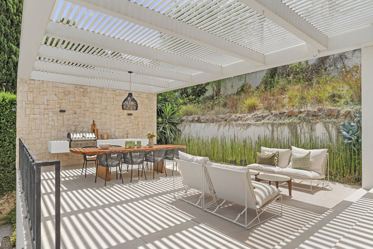 Pergola terrace with outdoor kitchen, dining table for eight and seating group