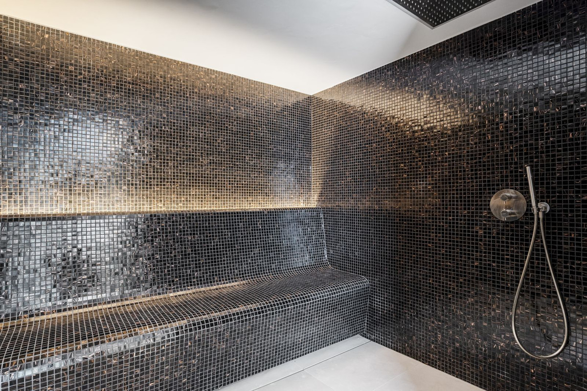 Hammam clad in black glass mosaic with concealed lighting