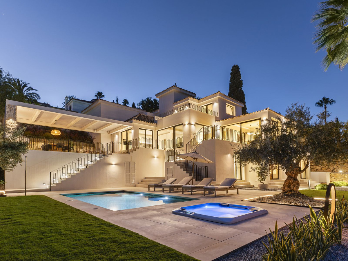 Illuminated facade, pool and jacuzzi at dusk